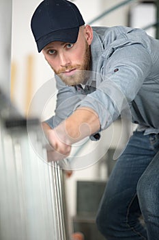 Man moving carefully ladder