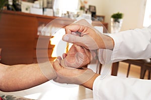 Man moving the hand of a senior patient