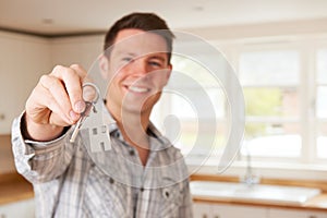 Man Moving Into New Home Holding House Shaped Keyring