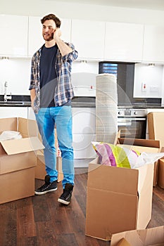 Man Moving Into New Home Talking On Mobile Phone
