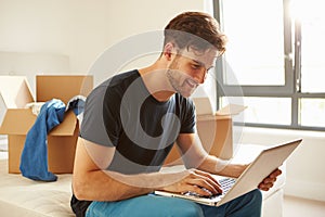 Man Moving Into New Home Using Laptop Computer