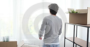 Man moving into new house and looking out through window