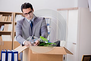 The man moving office with box and his belongings