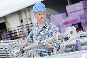 Man moving scaffold pole