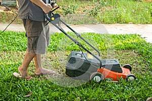 A man mow grass at his backyard