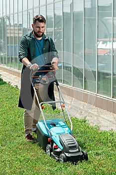 Man mowing the grass with an electric lawnmower