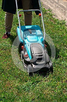 Man mowing the grass with an electric lawnmower