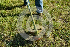 Man mowing grass on a rural lawn, close-up