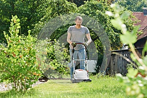 Man mowing lawn in backyard