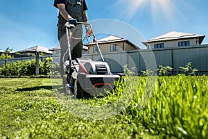 Man mowing lawn in the backyard of his house. Man with lawn mower