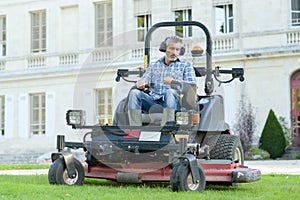 Man mowing lawn at manor house