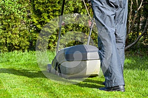 Man mowing with lawn mower in the garden