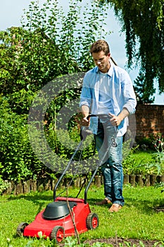 Man is mowing the lawn in summer