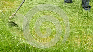 Man mows the grass with a hand-held lawn mower,household,close-up.