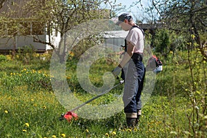 A man mows the grass on the lawn mowers. Overalls and tools