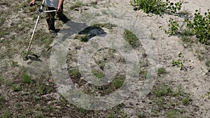 Man Mows the Grass with a Manual Petrol Lawn Mower