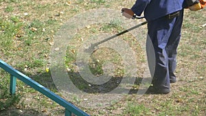 Man mows grass using a portable lawnmower