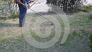 Man mows grass using a portable lawnmower