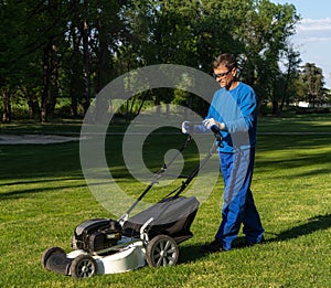 A man mows the lawn, the worker mows a lawn image,maintenance of greenery