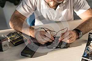 man with multimeter checking computer part