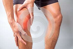 Man with muscle pain on grey background. Elderly have knee ache due to Runners Knee or Patellofemoral Pain Syndrome,