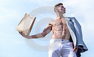 Man muscular athlete hold shopping bag sky background. Hot sales and discount. Guy attractive macho carry shopping bag