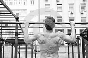 Man muscular back athlete doing pull ups with proper form, sport concept