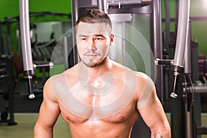 Man with muscular torso. Young man working out at a gym