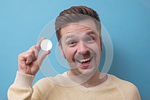 Man with mustache look at camera holdin g in fingers white circle as copyspace