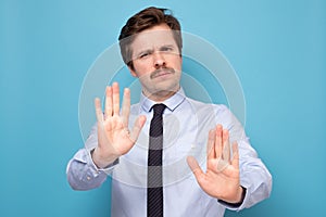 Man with mustache moving away hands palms showing refusal and denial gesture