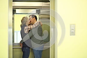 Man with a mustache and woman hugging and kissing