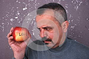 Man with mustaches looking Valentine apple