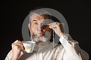 Man with muttonchops and funny expression holding monacle and cup of tea