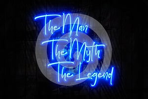 The Man, Myth, Legend, Blue Neon Sign on a Dark Wooden Wall
