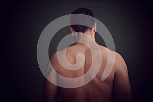 A man, naked, with his back