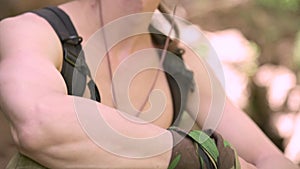 Man with naked torso, looks around. Blurred background of waterfall. Close-up