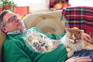 Man napping on couch with the cat during the holidays