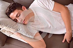 Man napping on a couch with cushions at home top