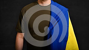 Man with the national flag of Ukraine on a black background.