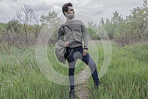 A man on the nature  with a backpack standing in the woods in the tall grass