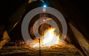 Man near camp fire at night