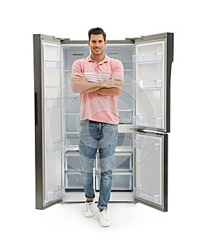 Man near empty refrigerator on white