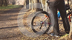 Man near the new red sports mountain bike bicycle on trail in