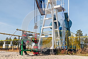 A man near the oil pump. Oil, gas industry. A man controls the process of the oil pump, the overall plan