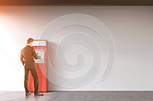 Man near a red ATM machine