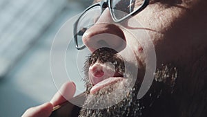 Man with a neat beard is talking on the phone: close-up of the mouth.