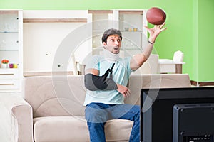 The man with neck and arm injury watching american football on tv