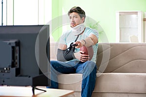 The man with neck and arm injury watching american football on tv
