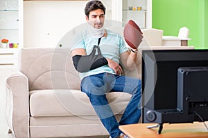 The man with neck and arm injury watching american football on tv