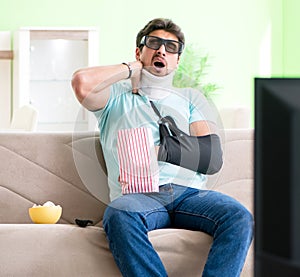 Man with neck and arm injury watching tv
